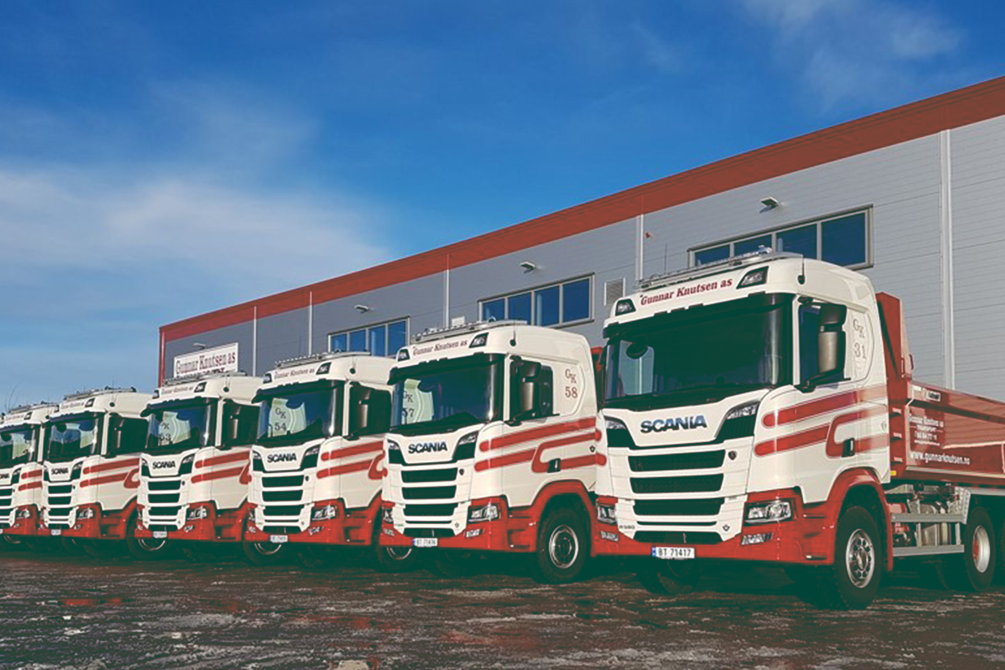 Six Gunnar Knudsen trucks parked next to each other